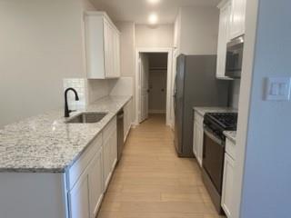 1201 Witherspoon Lane Princeton, TX 75407 - Photo 3 of 15 a kitchen with stainless steel appliances granite countertop a refrigerator and a sink