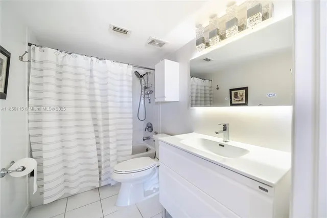 a bathroom with a sink a toilet and shower curtain