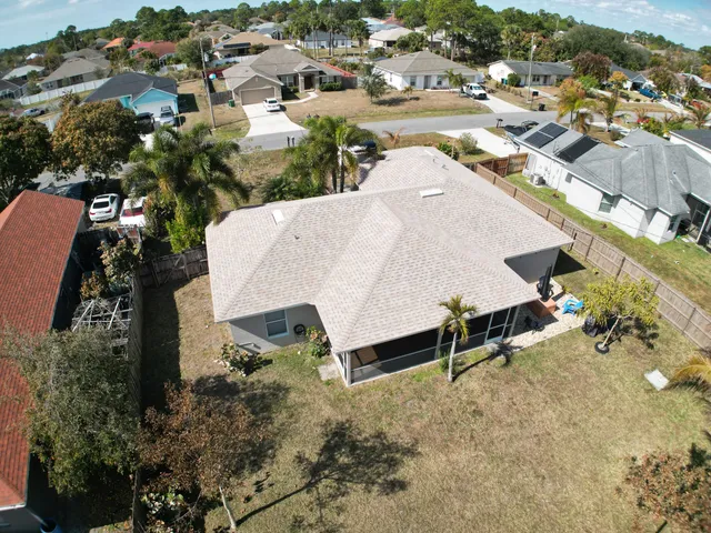 an aerial view of a house with a yard and lake view
