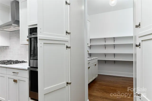 a view of a kitchen with wooden floor and cabinets