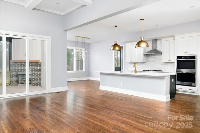 a large kitchen with kitchen island a large counter space a sink stainless steel appliances and cabinets