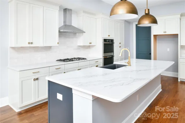a kitchen with stainless steel appliances granite countertop a sink a stove and a refrigerator