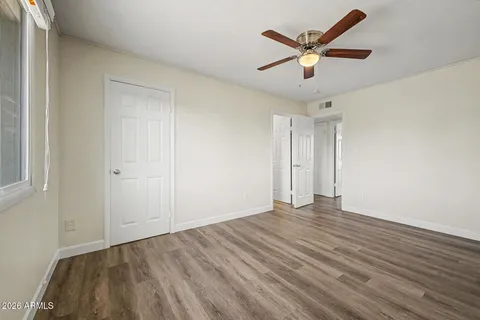 an empty room with a ceiling fan and a window