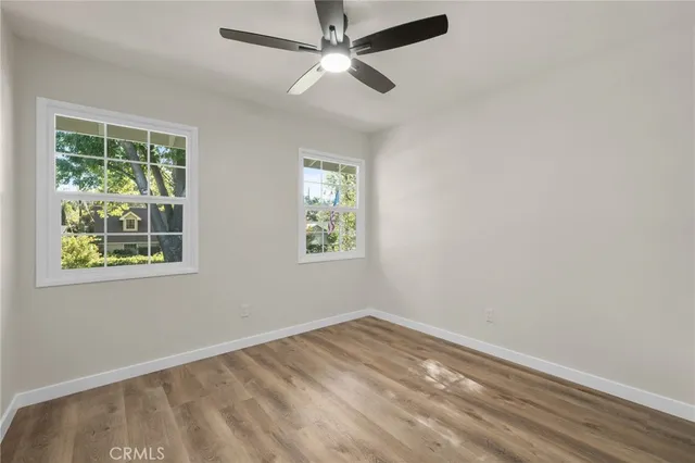 an empty room with windows and fan