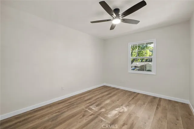 an empty room with a window and a ceiling fan