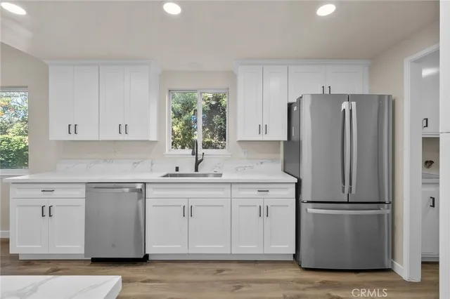 a kitchen with a refrigerator sink and cabinets