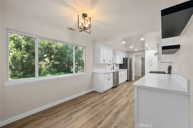 a large white kitchen with a large window