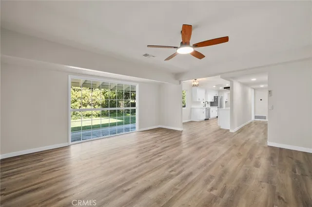 a view of empty room with wooden floor and window