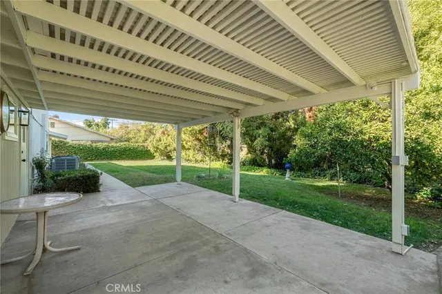 a view of a backyard with table and chairs under an umbrella