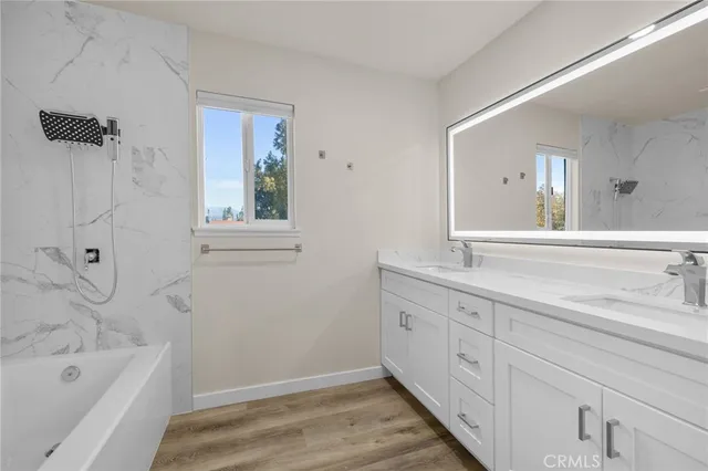 a bathroom with a tub sink and mirror