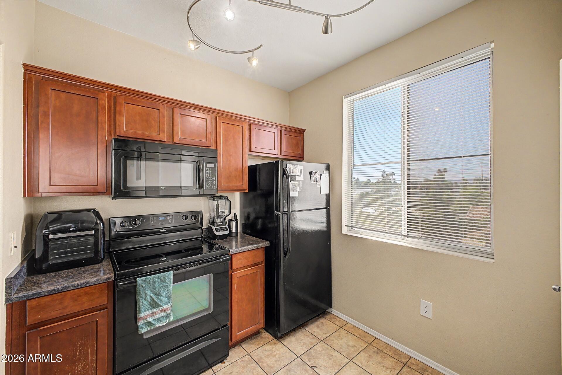 3302 North 7th Street, Unit 354 Phoenix, AZ 85014 - Photo 11 of 32 a kitchen with stainless steel appliances a refrigerator a stove a sink and a cabinets
