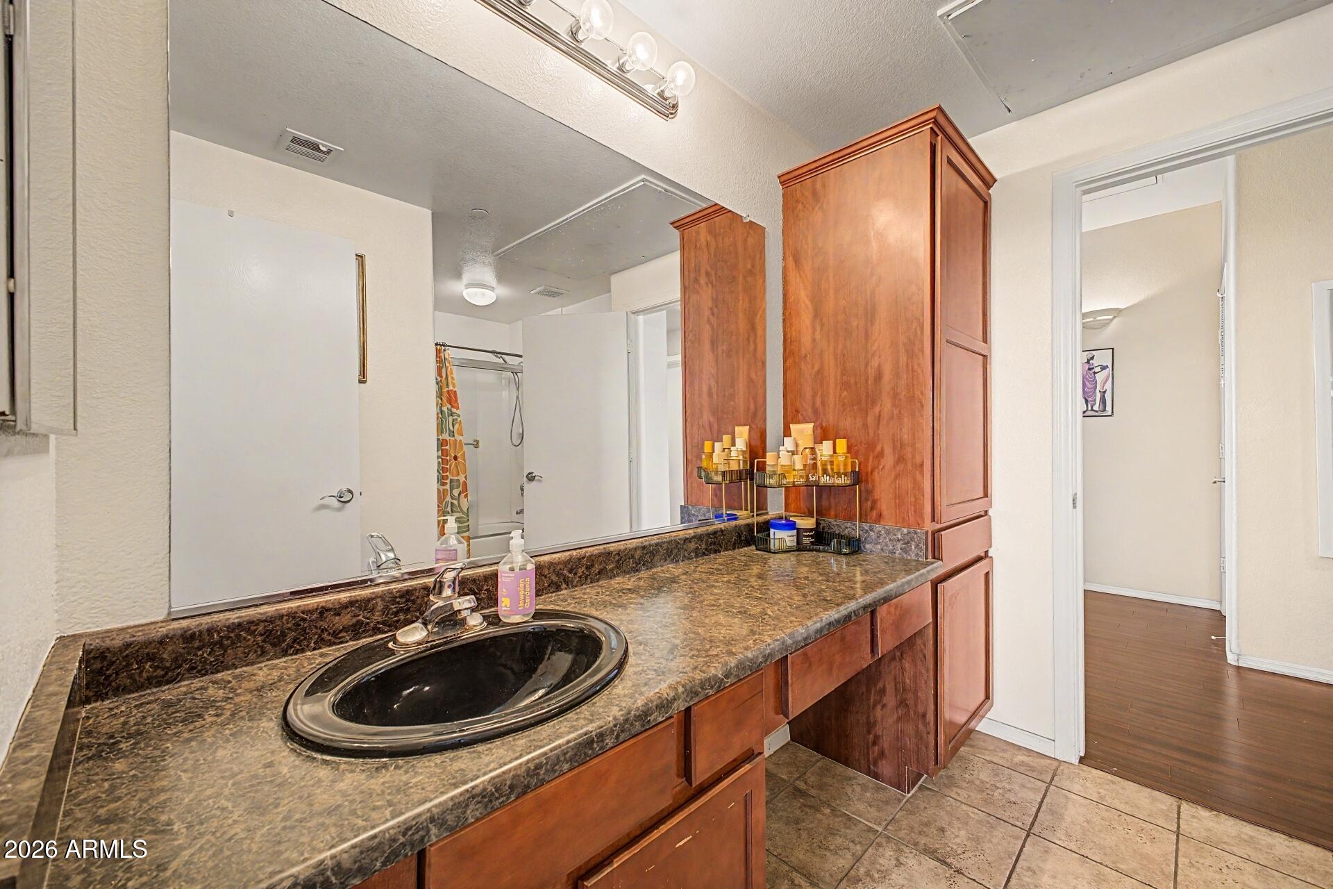 3302 North 7th Street, Unit 354 Phoenix, AZ 85014 - Photo 20 of 32 a bathroom with a granite countertop sink and a mirror