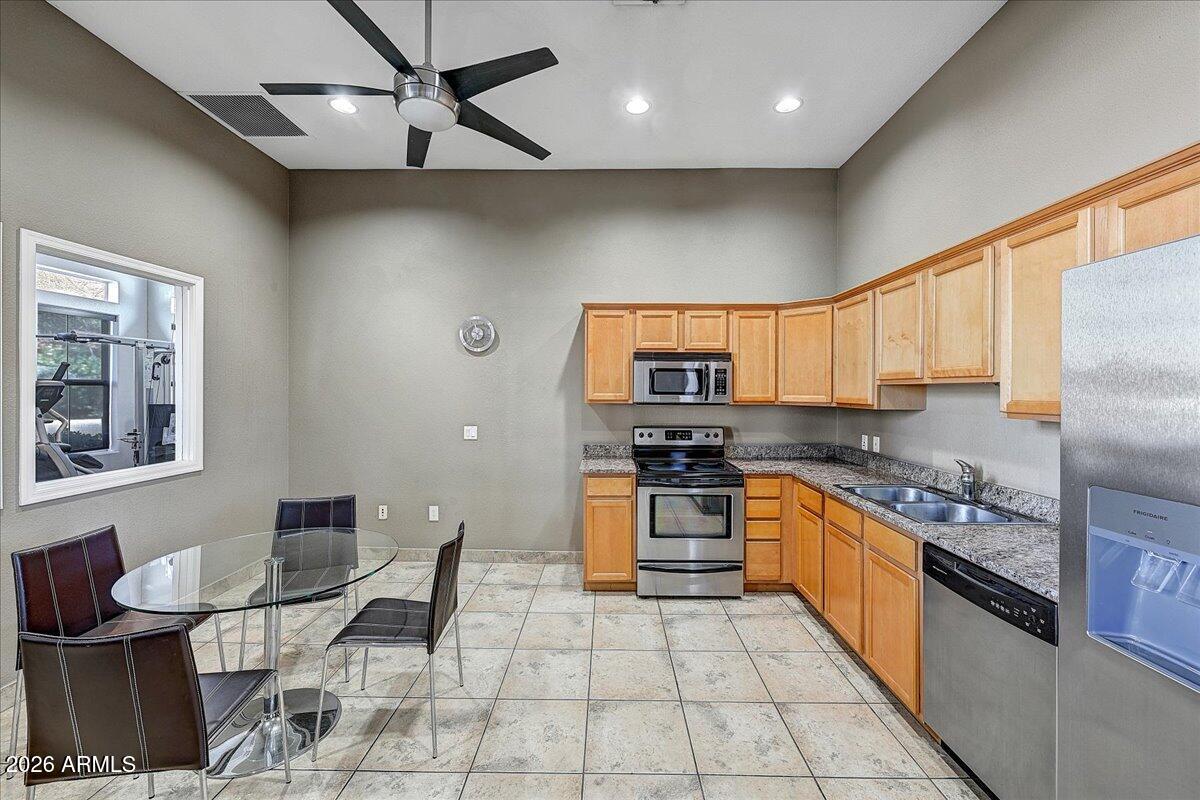 3302 North 7th Street, Unit 354 Phoenix, AZ 85014 - Photo 28 of 32 a kitchen with stainless steel appliances granite countertop a stove top oven a sink a dining table and chairs with wooden floor
