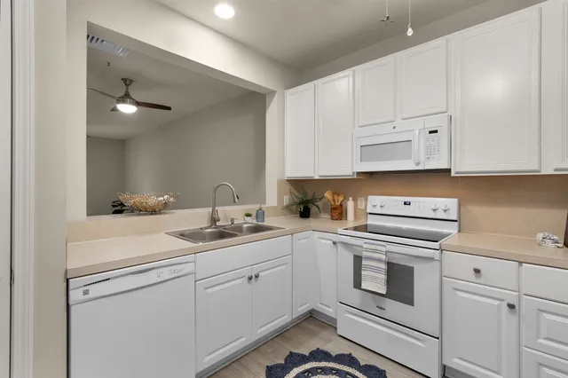a kitchen with white cabinets stainless steel appliances and sink