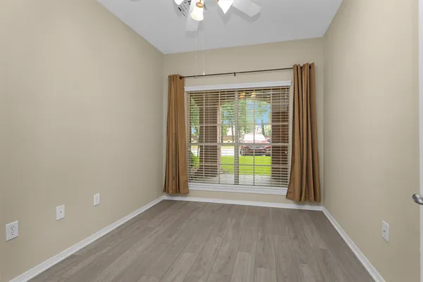 an empty room with wooden floor and a window