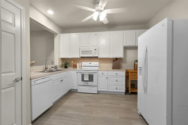 a kitchen with white cabinets and stainless steel appliances