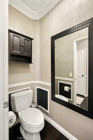 a white toilet sitting next to a bathroom and mirror