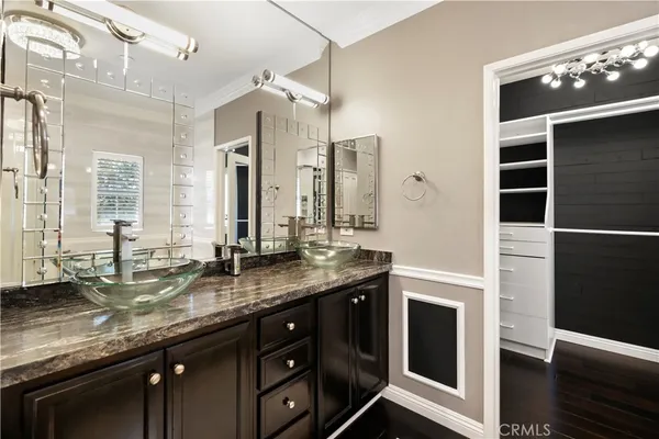 a bathroom with a granite countertop sink a large mirror and a shower