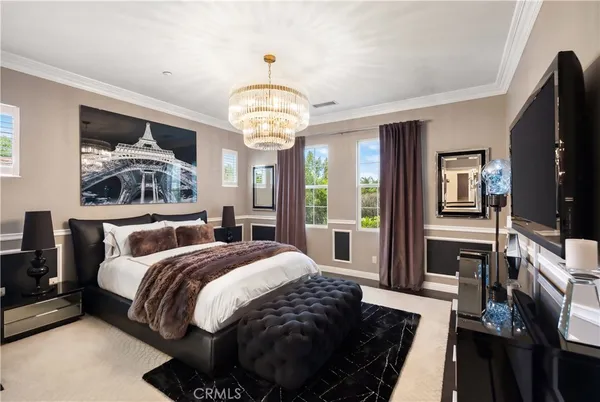 a bedroom with a bed and a chandelier