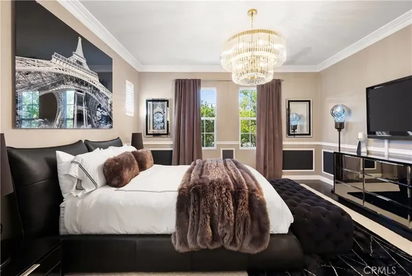 a bedroom with a bed and a chandelier