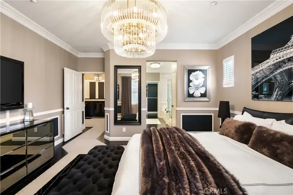 a spacious bedroom with a bed and a chandelier