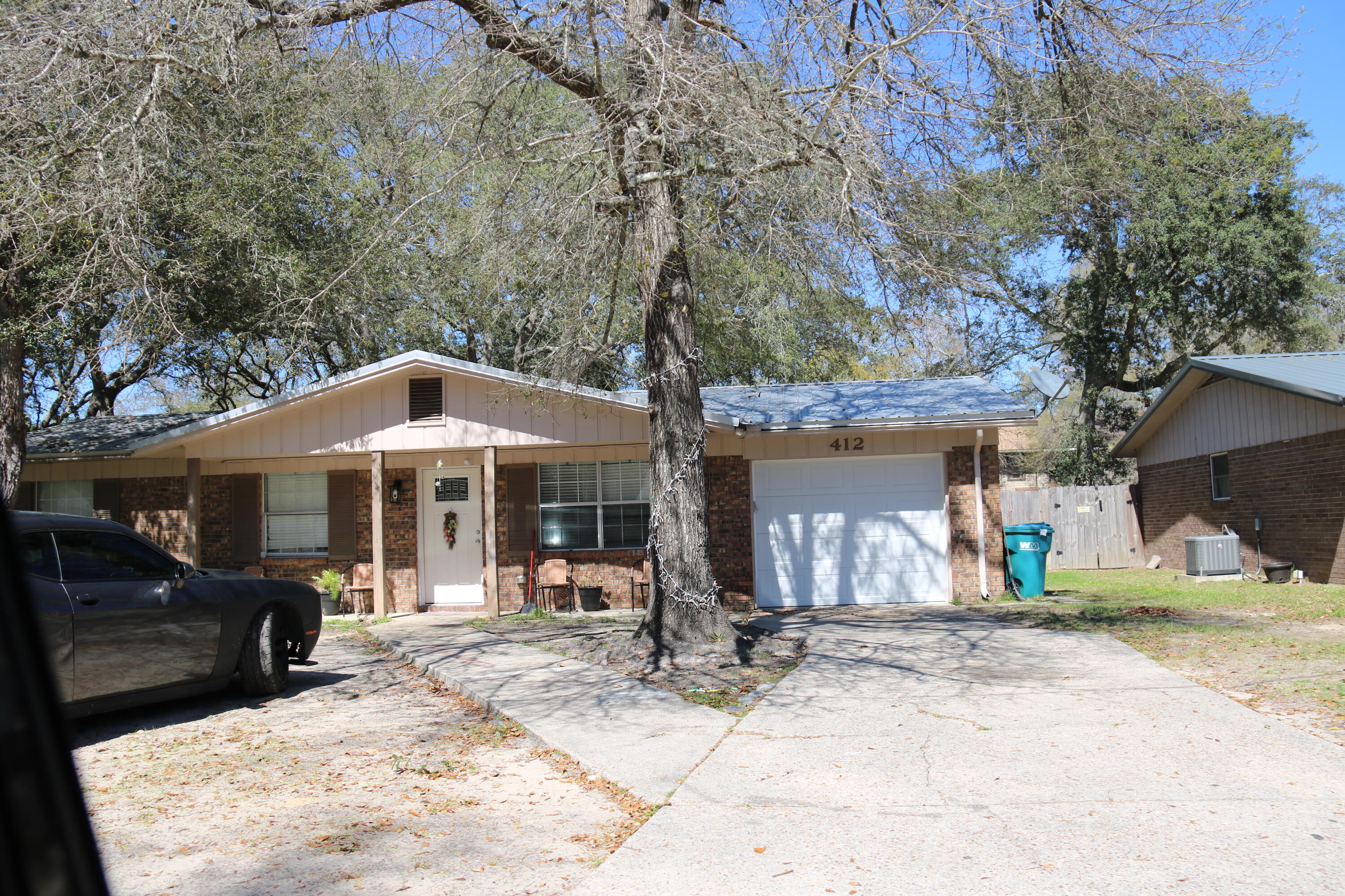 412 Bear Road Fort Walton Beach, FL 32547 - Photo 1 of 3 a view of a white house with large windows next to a road