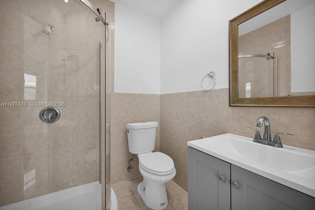 666 Kathy Court Pompano Beach, FL 33068 - Photo 15 of 45 a bathroom with a toilet a sink a mirror and shower