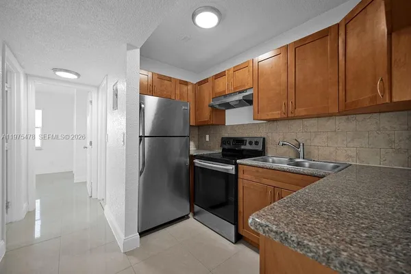 a kitchen with stainless steel appliances granite countertop a refrigerator sink and cabinets