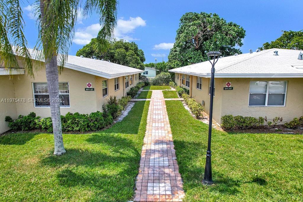 666 Kathy Court Pompano Beach, FL 33068 - Photo 43 of 45 a front view of house with yard and green space