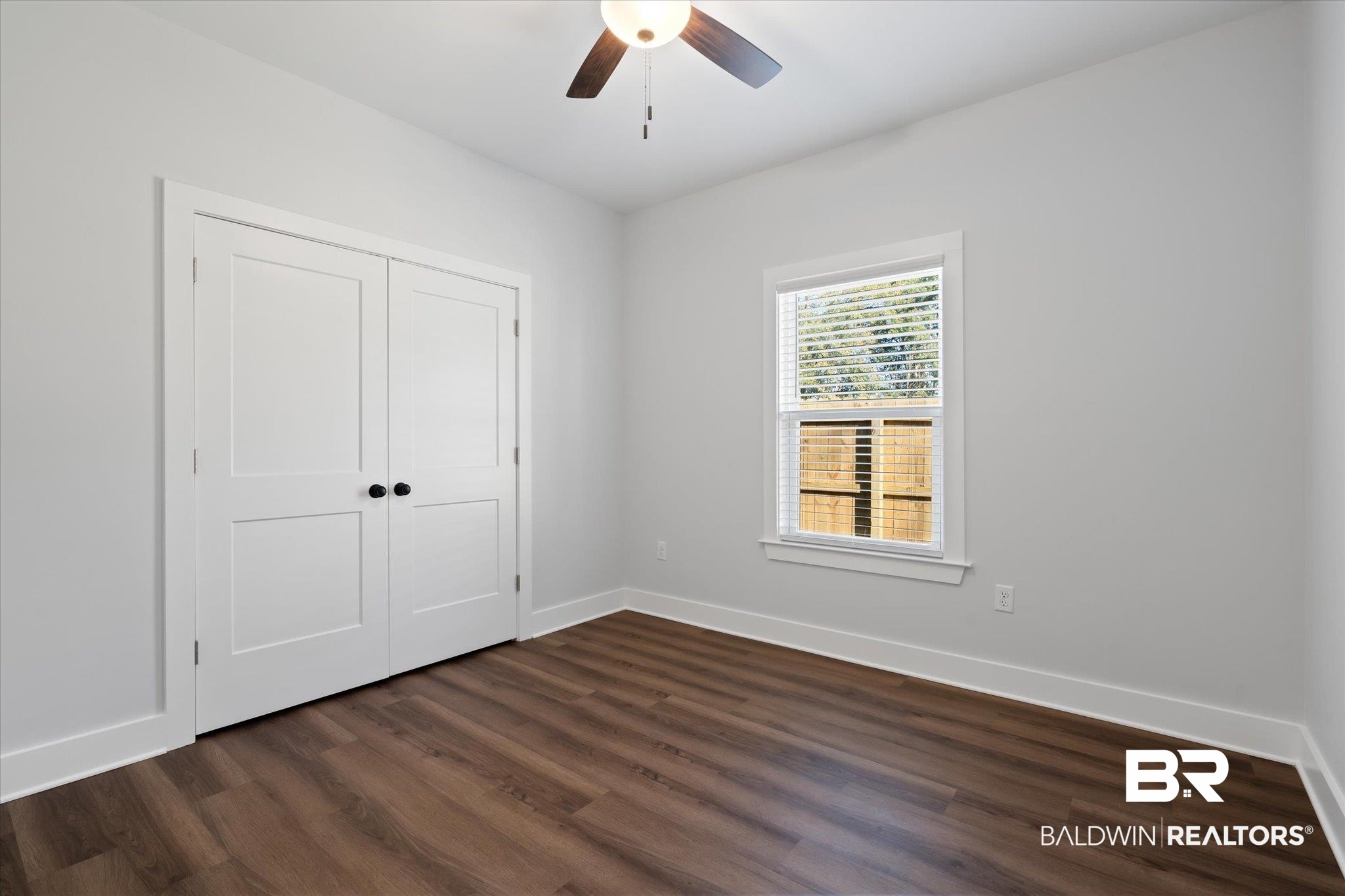 18151 Hoiles Street Robertsdale, AL 36567 - Photo 15 of 23 Unfurnished bedroom featuring ceiling fan, dark hardwood / wood-style flooring, and a closet