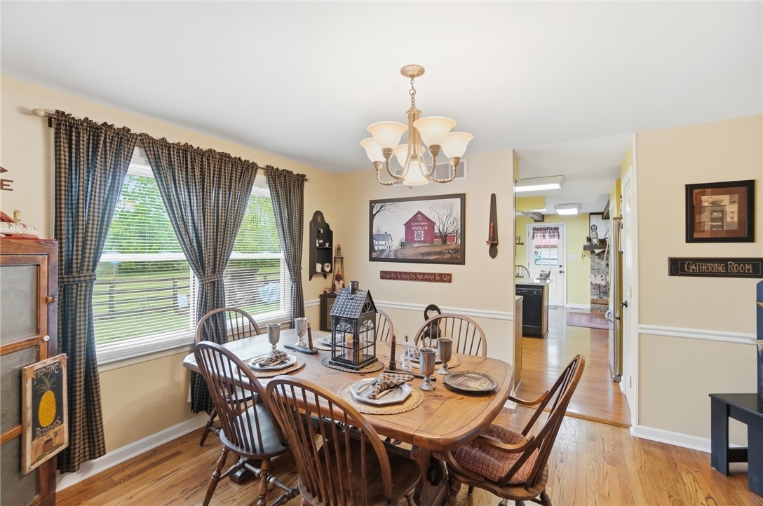 4170 Johnson Road Springfield, OH 45502 - Photo 19 of 54 A welcoming dining area features hardwood floors and a classic chandelier, offering a pleasant space for gatherings.