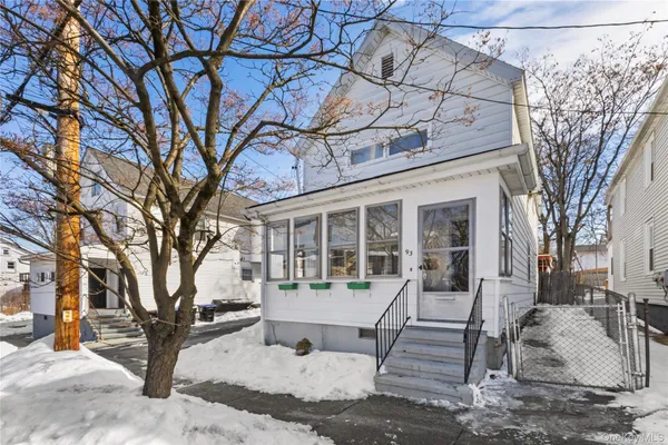 a view of a house with a yard covered in snow