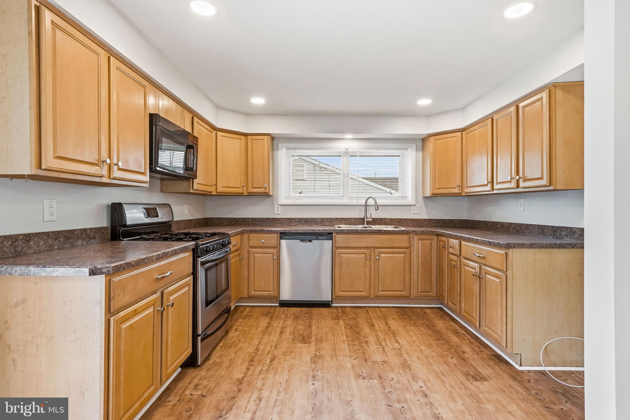 1286 Glassboro Road Williamstown, NJ 08094 - Photo 11 of 41 a kitchen with stainless steel appliances granite countertop wooden cabinets a stove a sink and dishwasher with wooden floor