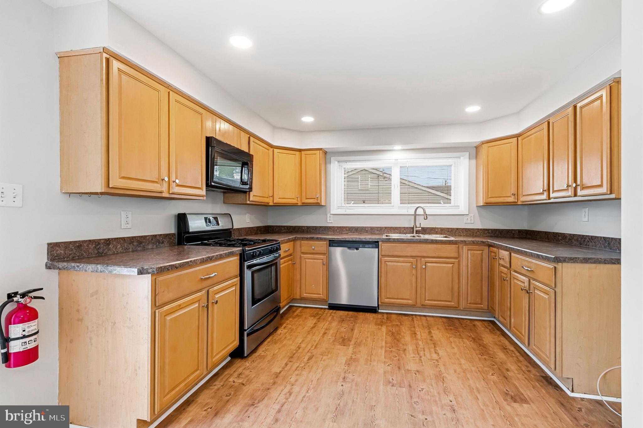 1286 Glassboro Road Williamstown, NJ 08094 - Photo 12 of 41 a kitchen with stainless steel appliances granite countertop wooden cabinets a stove a sink and a microwave