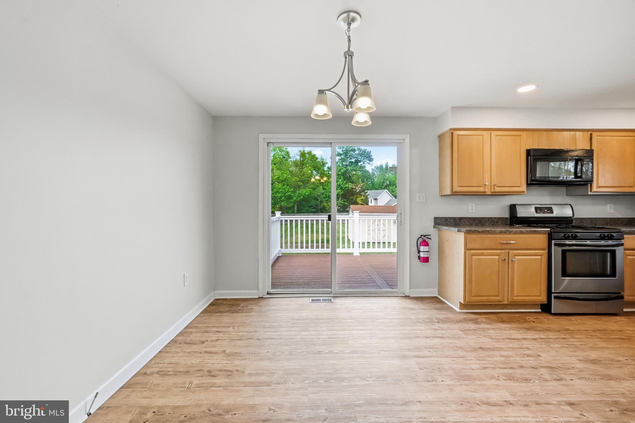 1286 Glassboro Road Williamstown, NJ 08094 - Photo 15 of 41 a view of livingroom with kitchen island stainless steel appliances wooden floor and window