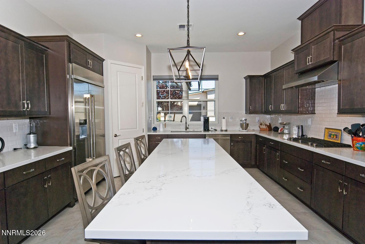 2332 Hammer Falls Drive Reno, NV 89521 - Photo 16 of 57 a kitchen with kitchen island granite countertop a large counter top space a sink stainless steel appliances and cabinets