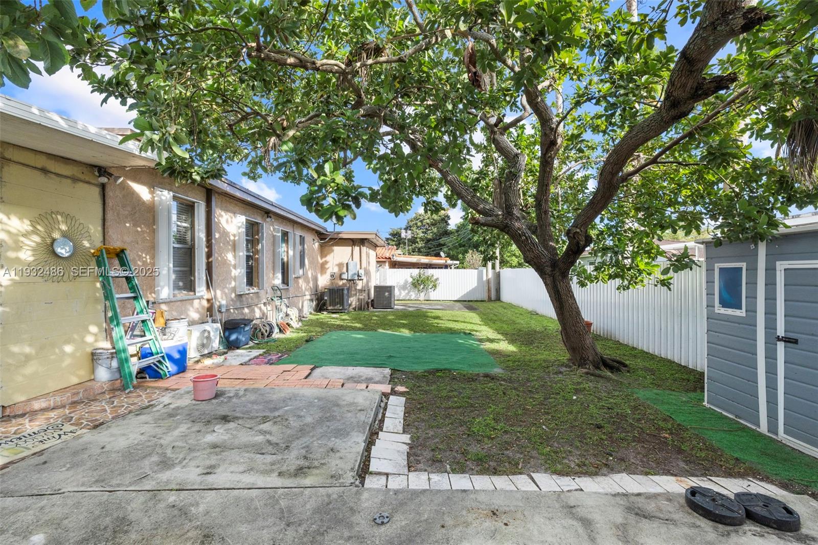 60 West 61st Street Hialeah, FL 33012 - Photo 20 of 43 a view of a yard with a tree and a table and chair