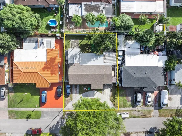 an aerial view of a house with a yard and potted plants