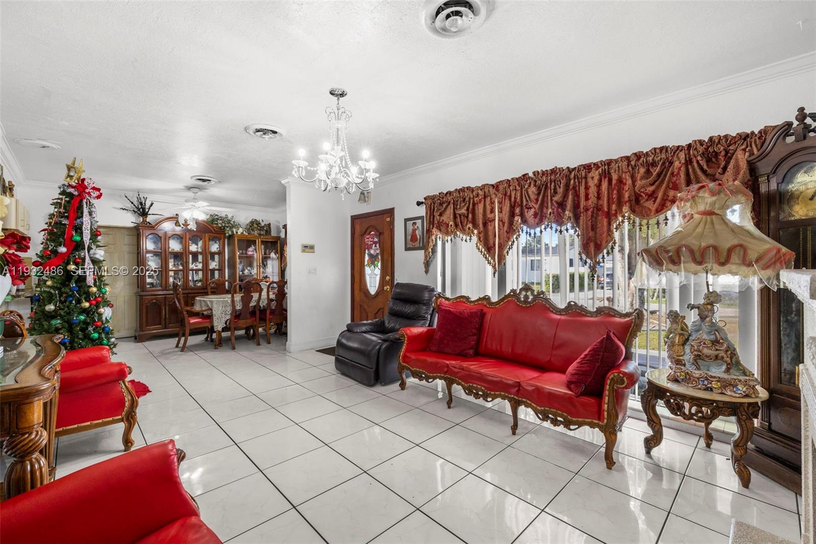 60 West 61st Street Hialeah, FL 33012 - Photo 5 of 43 a bedroom with furniture and a chandelier