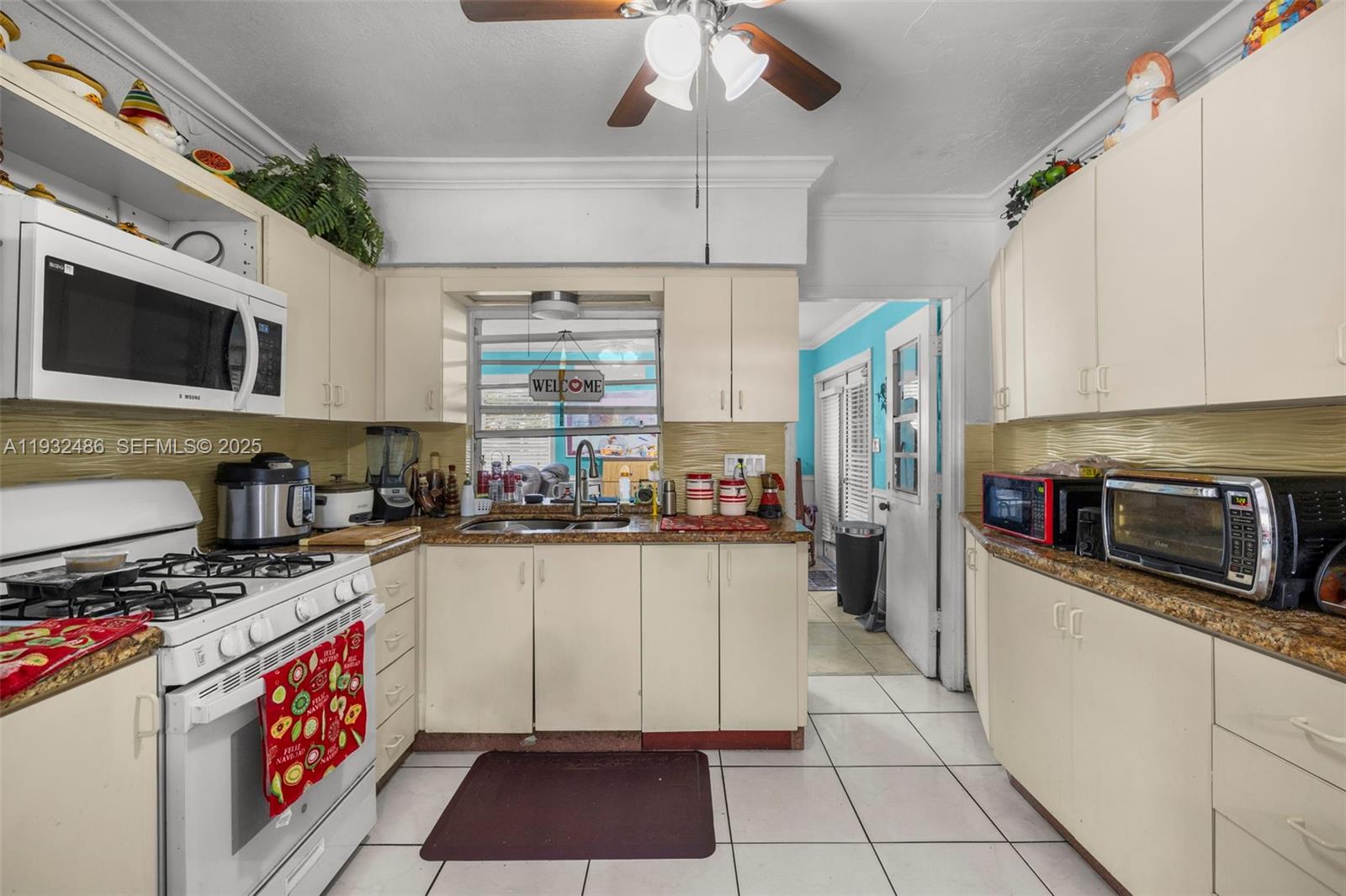 60 West 61st Street Hialeah, FL 33012 - Photo 8 of 43 a kitchen with stainless steel appliances a stove a sink cabinets and a counter top space