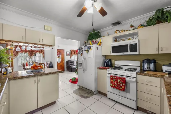 a view of a kitchen with fridge and workspace