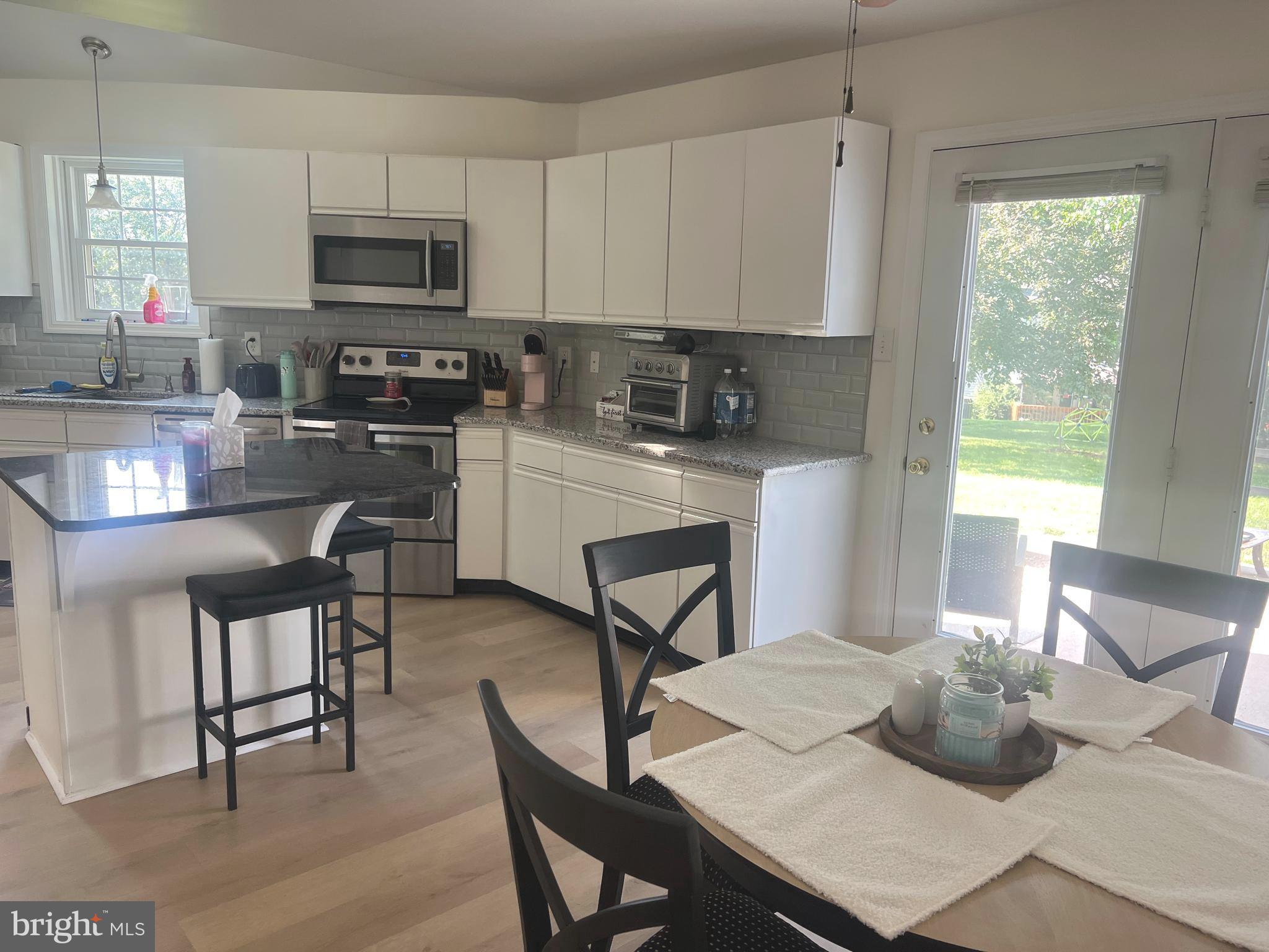112 Spring Ridge Court Lancaster, PA 17601 - Photo 4 of 19 a kitchen with stainless steel appliances a dining table a stove a microwave and cabinets