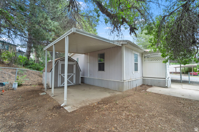 2875 North 400 West, Unit 7 Layton, UT 84041 - Photo 2 of 29 Exterior featuring a covered patio, a storage shed with a gambrel roof, and a gravel driveway