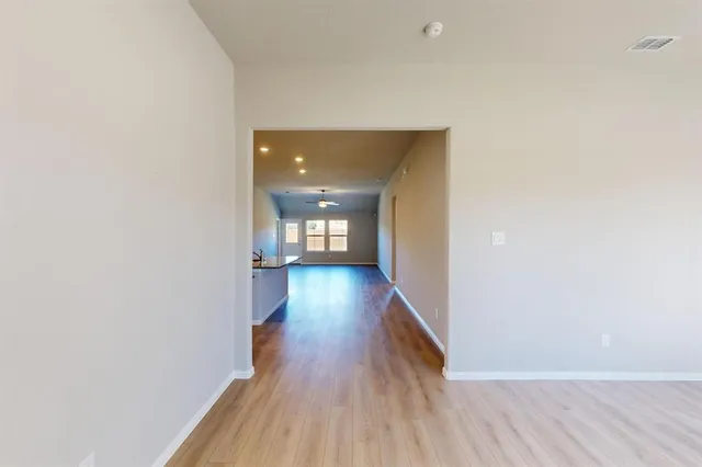 a view of a hallway with wooden floor