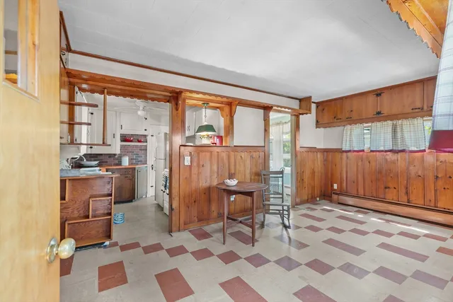 a living room with a black white checkered floor with a dining table and chairs
