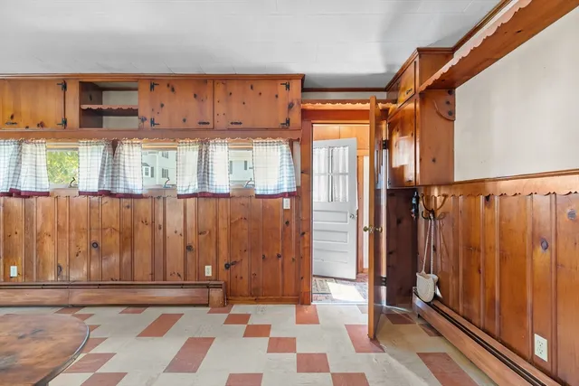 a view of a hallway with wooden floor and dining room view