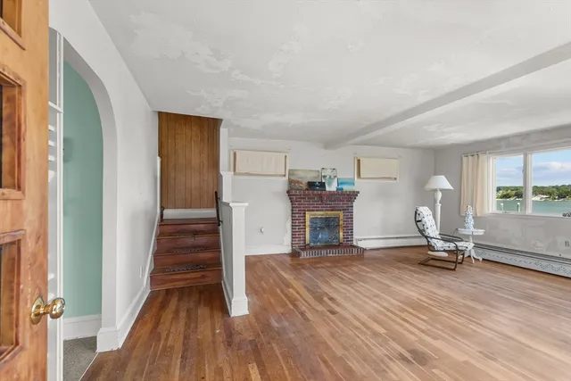 a view of a room with wooden floor and furniture