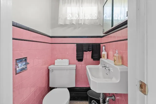 a bathroom with a sink a toilet and mirror