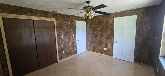 an empty room with windows and fireplace