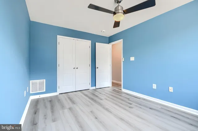 an empty room with a ceiling fan and carpet
